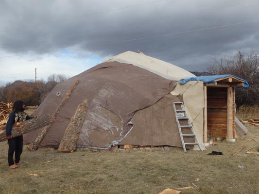 Earthlodge temporarily covered with tarps.