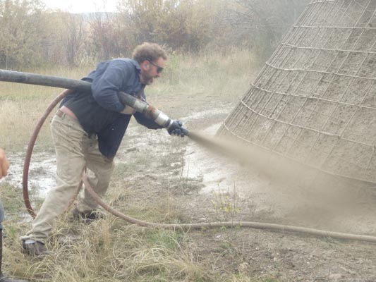 Spraying shotcrete alone.