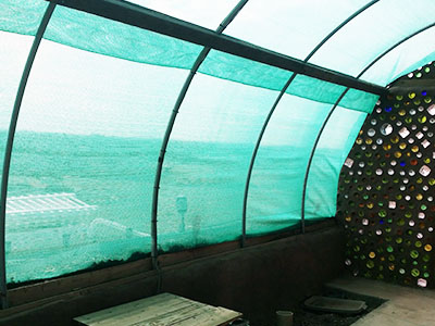 Shade cloth over greenhouse hoops.