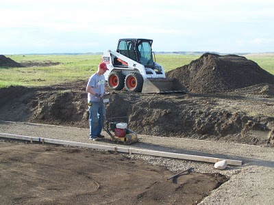 Compacting crushed stone for under footing.