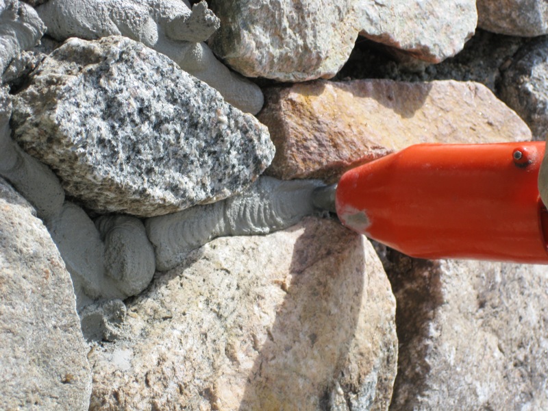 Squeezing mortar between stones with a Quickpoint mortar gun.