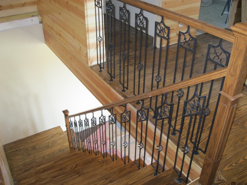 Completed staircase with wooden tread and decorative metal ballisters.