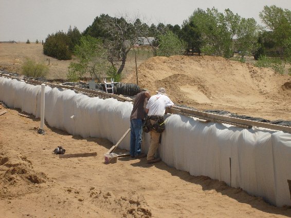 Tire bales wrapped in plastic and earth-bermed.