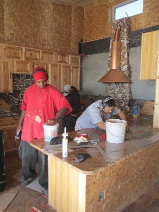 Installing kitchen cabinetry  and granite countertops.