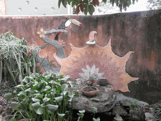 Masonry wall with sun motif and garden.