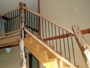 Stairs to loft with log poles.