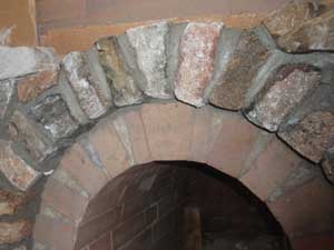 Stonework over brick arch close-up.