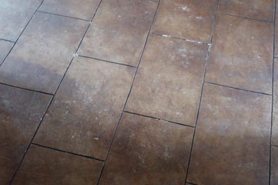 Concrete floor dyed and groved to look like tiles.