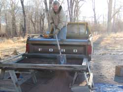 Sifting soil for a terra tile floor.